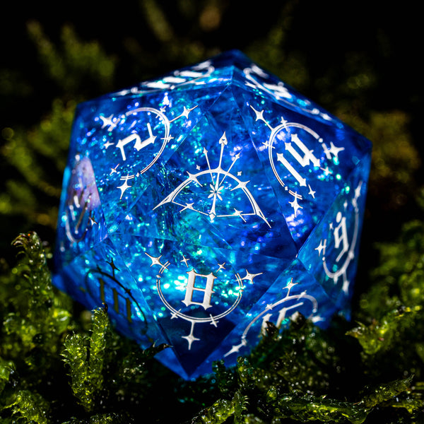 a blue dice sitting on top of a pile of green grass
