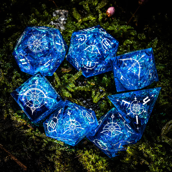 a group of blue dice sitting on top of a lush green field