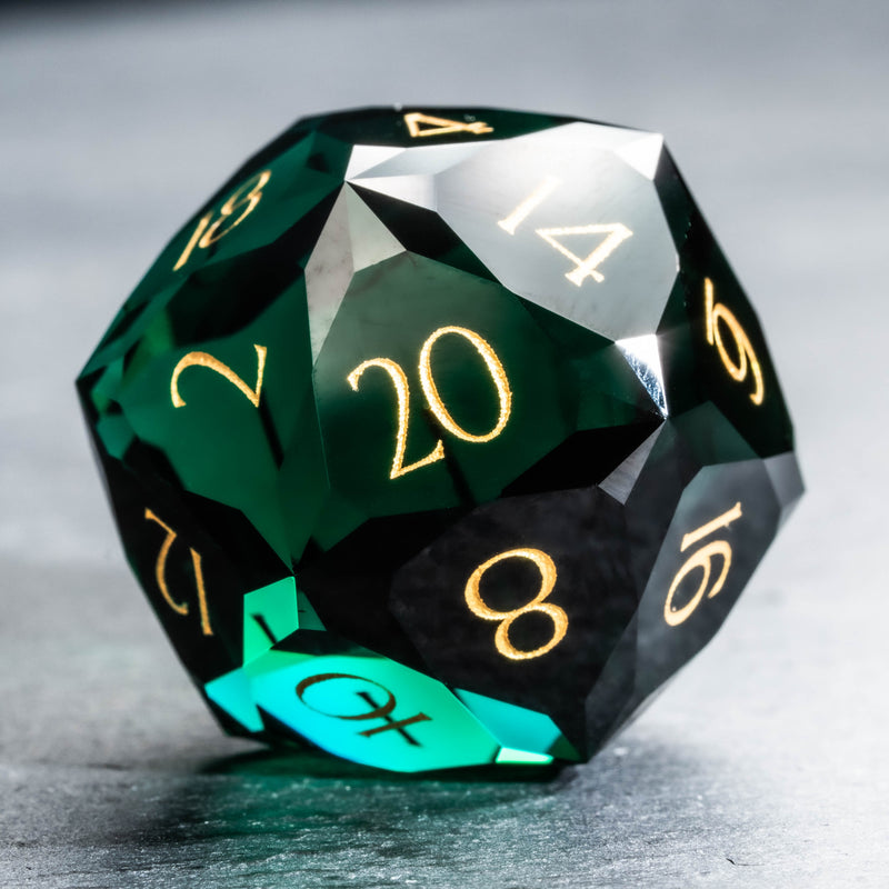 a green and black dice with gold numbers on it