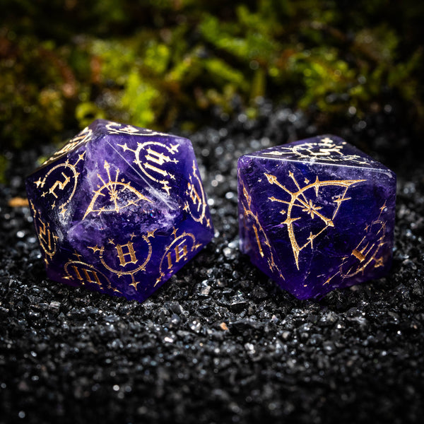 two purple dices with gold designs on them