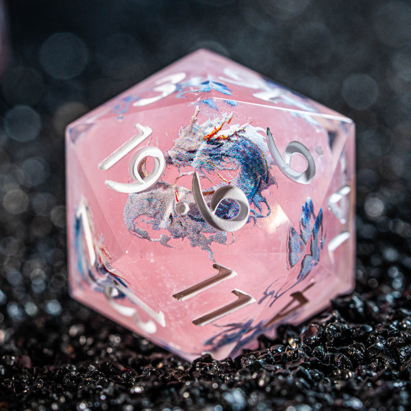 a close up of a pink dice on a black surface