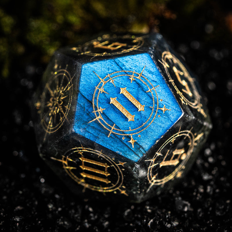 a blue and gold dice sitting on top of a black surface