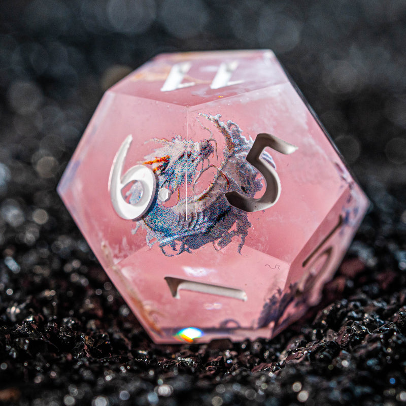 a close up of a pink dice with a zodiac sign on it