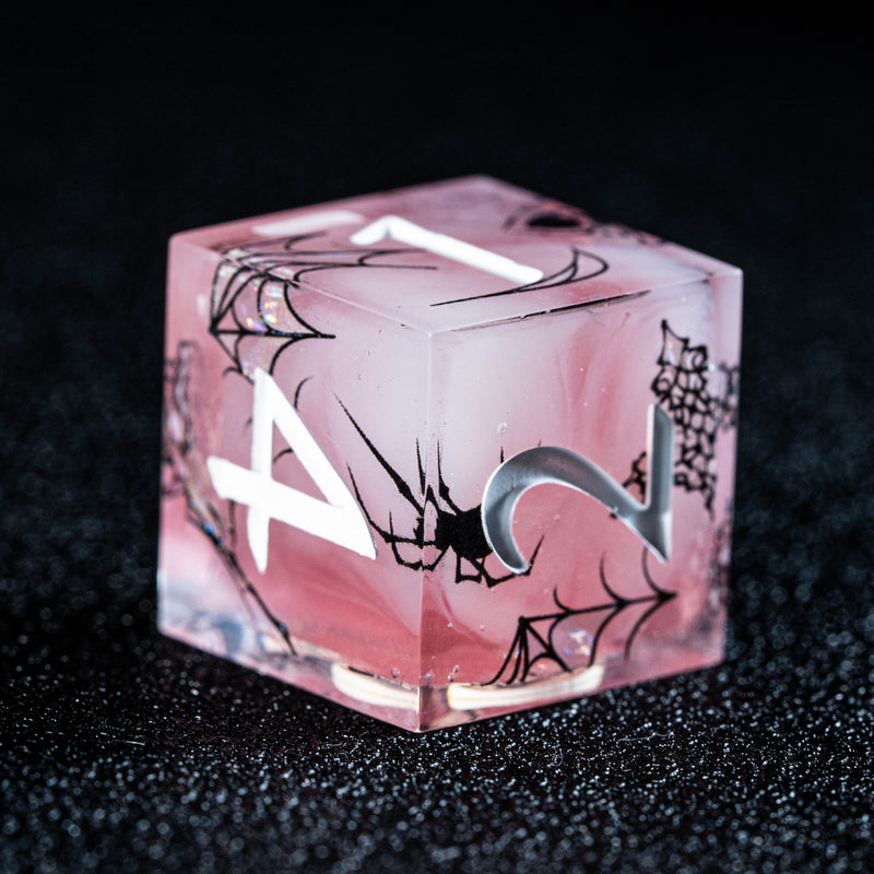 a pink dice sitting on top of a black table