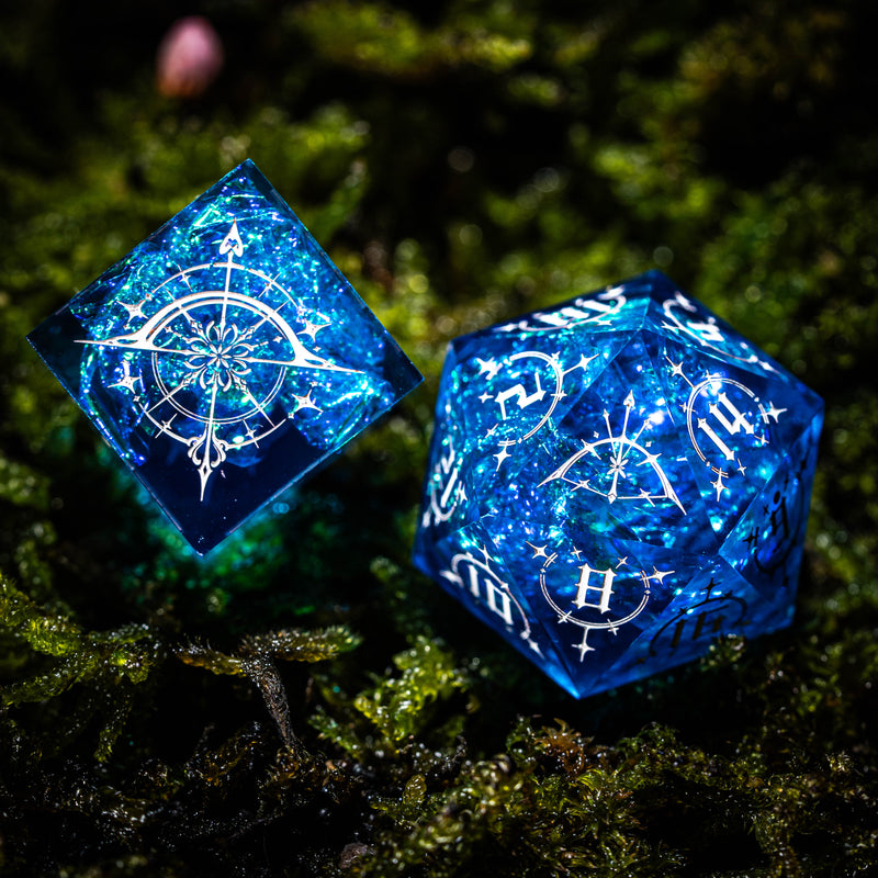 two blue dices sitting on top of a moss covered ground