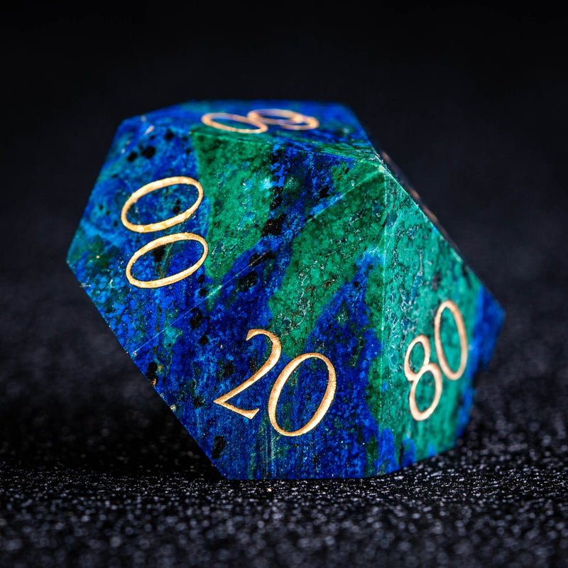 a blue and green marble dice with gold numbers