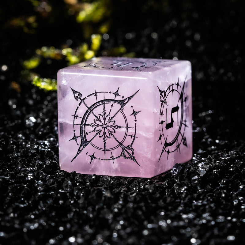 a pink dice sitting on top of a black table