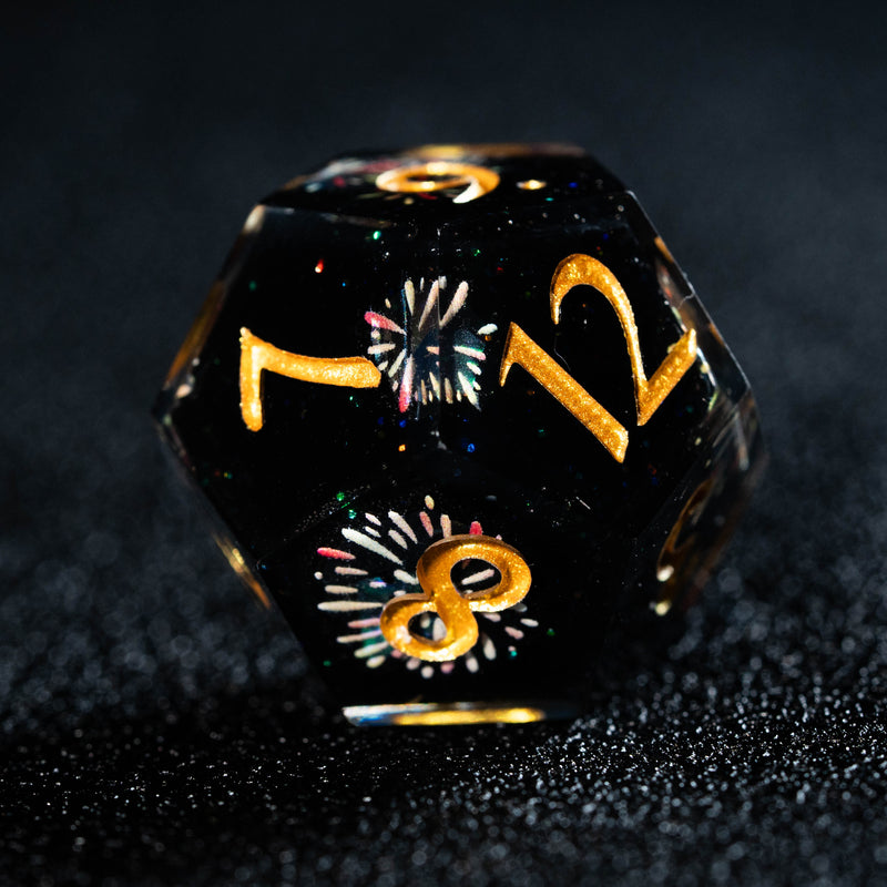 a black dice with gold numbers and fireworks