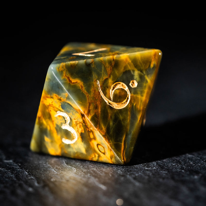 a marble dice with gold numbers on it