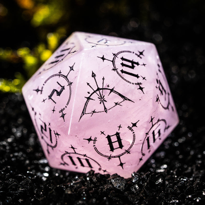 a close up of a pink dice on a black surface