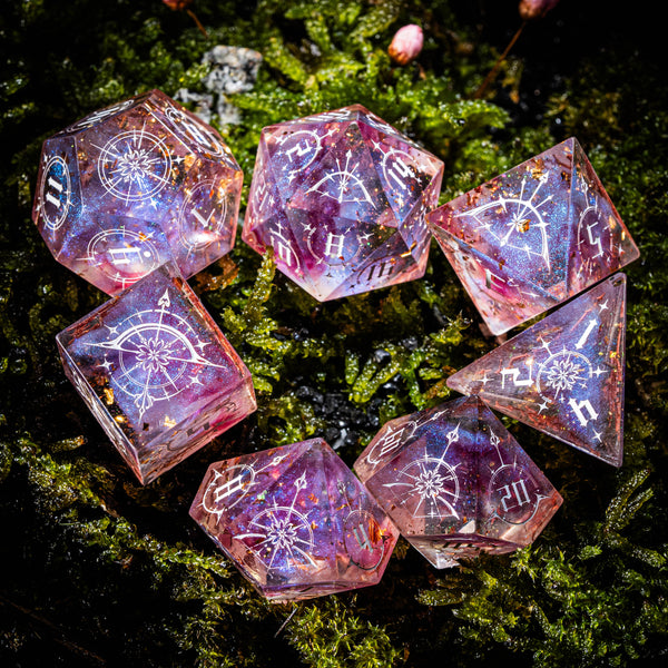 a group of pink dices sitting on top of a moss covered ground