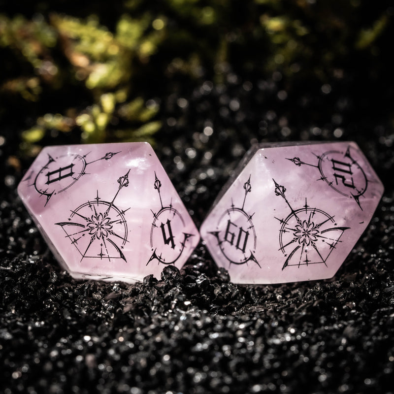 a pair of pink dices sitting on top of a black ground