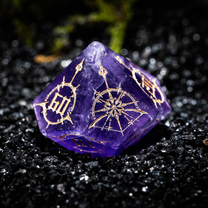 a close up of a purple dice on a black surface