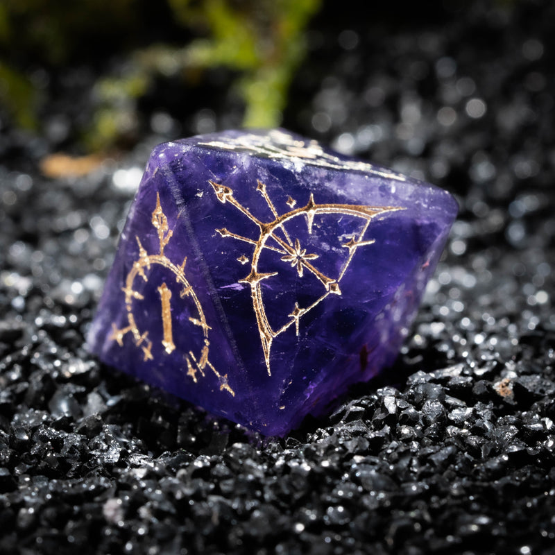 a purple rock with gold designs on it