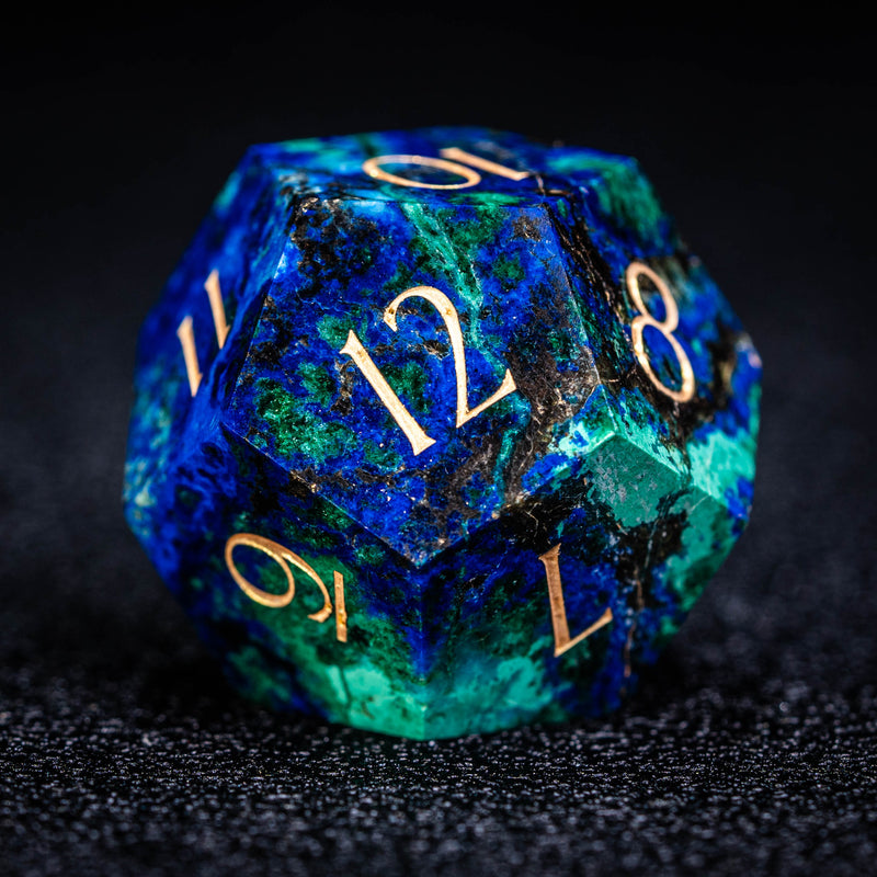 a blue and green dice with gold numbers on it