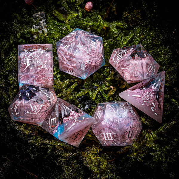 a group of pink dices sitting on top of a moss covered ground