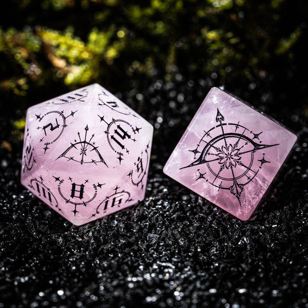 two pink dices sitting on top of a black surface
