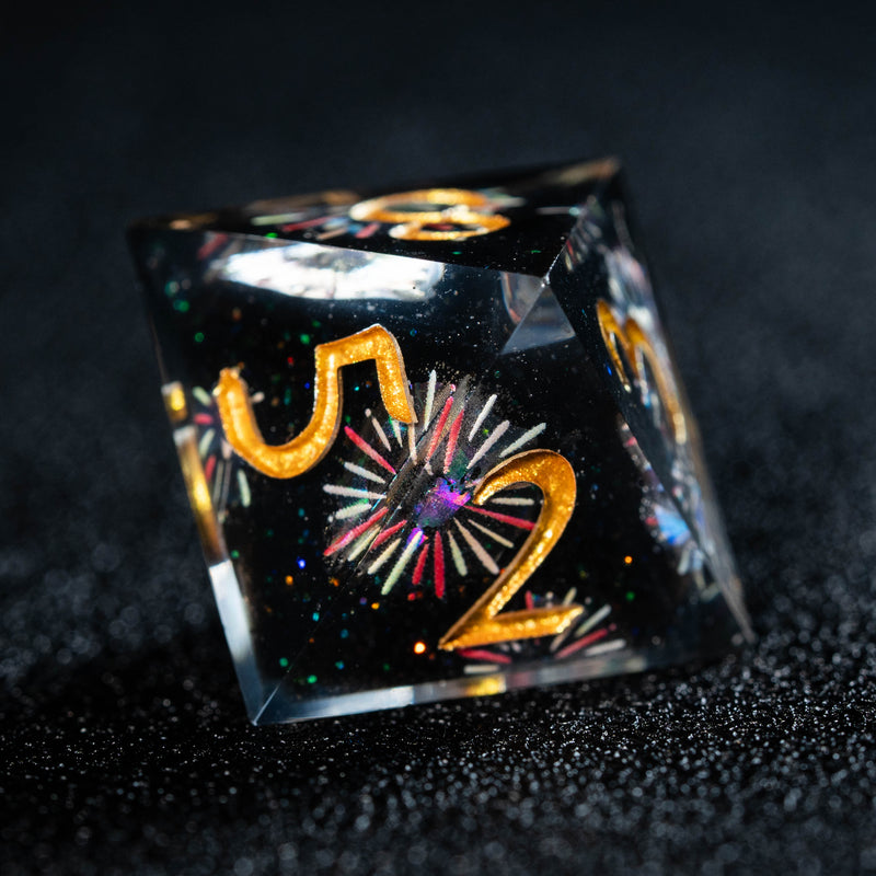 a black dice with gold numbers and fireworks