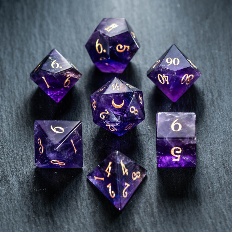 a group of purple and gold dice sitting on top of a table